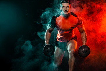 Fototapeta na wymiar Muscular fitness sports man, atlete with dumbbell in fitness gym. Energy and power.
