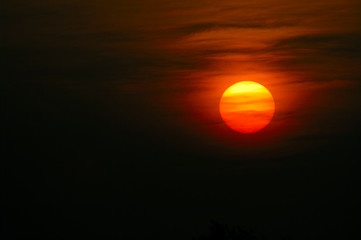 Orange sun with misty clouds