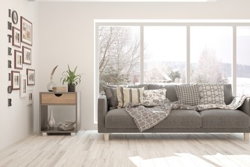 Stylish room in white color with sofa and winter landscape in window. Scandinavian interior design. 3D illustration