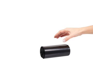 hand with roll of black plastic garbage bags for trash