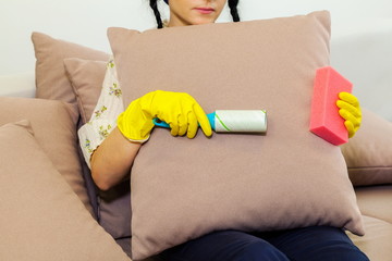 Woman cleaning sofa with lint roller