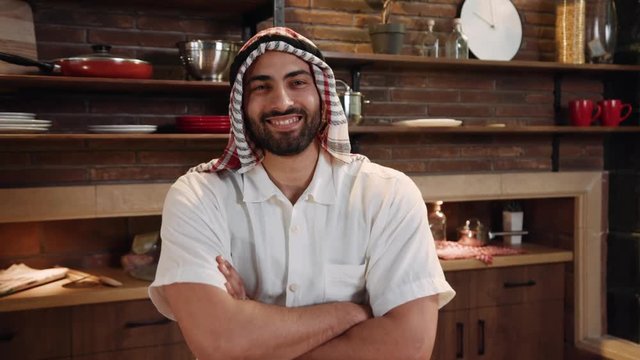 Portrait smiling young man wearing traditional emirates clothes look at camera happy male saudi arab arabic business muslim traditional sheik posing headscarf sheikh face close up slow motion