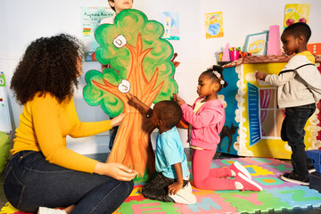 Kids learn alphabet put letters on tree in nursery