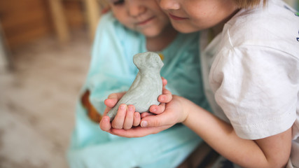 children siblings are holding dove of clay
