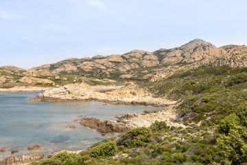 Fototapeta na wymiar jagged red rocks on the coast of the Desert des Agriates at Ostriconi in the Balagne region of Corsica, France