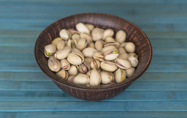 Healthy food  for background image close up pistachios nuts. Texture on white grey table top view. Nuts pistachio on the cup plate