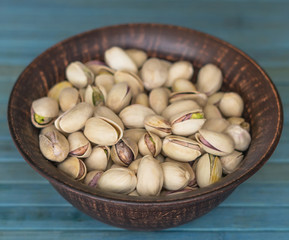 Healthy food  for background image close up pistachios nuts. Texture on white grey table top view. Nuts pistachio on the cup plate
