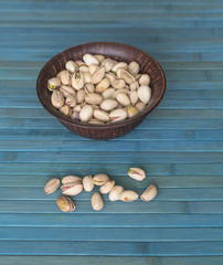 Healthy food  for background image close up pistachios nuts. Texture on white grey table top view. Nuts pistachio on the cup plate