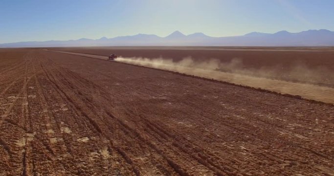 SALAR DE TARA, ATACAMA DESERT, CHILE - JUNE 2016. A bumpy off-road ride into a wide expanse of desert. Aerial 4K view over the bare deserted ground.