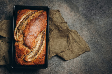 Banana bread with nuts, honey and mint on a dark background.