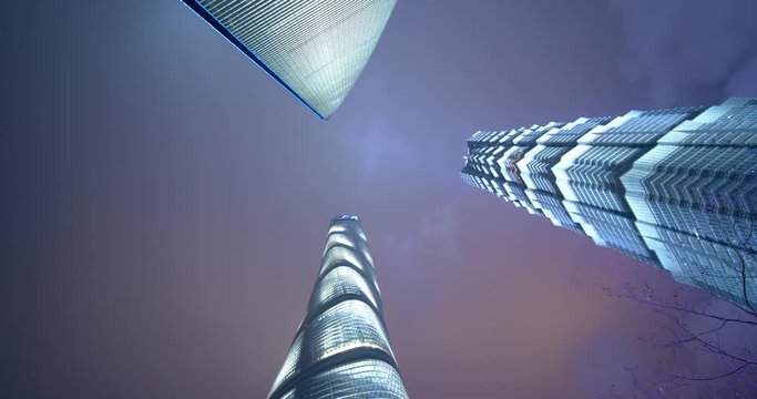 Shanghai towers lighted up in the evening look up view