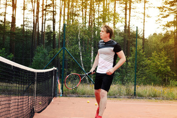 Male tennis player during workout on the evening sunset