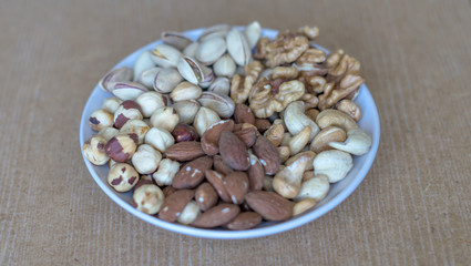 Healthy food. Nuts mix assortment on white grey table top view. Collection of different legumes for background image close up nuts, pistachios, almond, cashew nuts, peanut, walnut. image