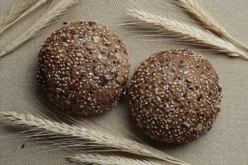 Pão multigrãos com uvas passas em mesa com trigo