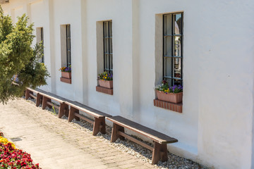 Fototapeta na wymiar Mediterranes weißes Haus mit liebevoll gestalteten Grundstück mit Holzbänken und Blumenkästen