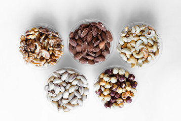 Healthy food. Nuts mix assortment on white grey table top view. Collection of different legumes for background image close up nuts, pistachios, almond, cashew nuts, peanut, walnut. image