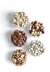 Healthy food. Nuts mix assortment on white grey table top view. Collection of different legumes for background image close up nuts, pistachios, almond, cashew nuts, peanut, walnut. image