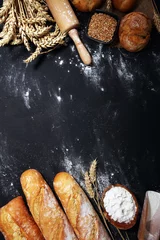 Foto op Canvas Assortiment van gebakken brood en broodjes op rustieke zwarte bakkerijtafelachtergrond © beats_