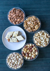  Oriental dessert halva with pistachio, almond, cashew nuts, peanut, walnut  on a  plate. Image. Healthy food. Nuts mix assortment. sweets, Turkish Delight. Isolated  background.. Eastern delicacy