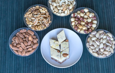  Oriental dessert halva with pistachio, almond, cashew nuts, peanut, walnut  on a  plate. Image. Healthy food. Nuts mix assortment. sweets, Turkish Delight. Isolated  background.. Eastern delicacy