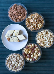  Oriental dessert halva with pistachio, almond, cashew nuts, peanut, walnut  on a  plate. Image. Healthy food. Nuts mix assortment. sweets, Turkish Delight. Isolated  background.. Eastern delicacy