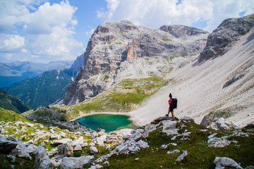 Young active hiker tourist woman walking/hiking Tre Cime di Lavaredo trail in Dolomites, Italy, Europe. Beautiful mountain scenic landscape view. Summer outdoor activity or active holiday concept.