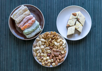 Oriental dessert halva with pistachio, almond, cashew nuts, peanut, walnut  on a  plate. Image. Healthy food. Nuts mix assortment. sweets, Turkish Delight. Isolated  background.. Eastern delicacy