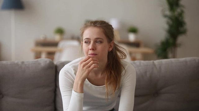 Stressed upset girl worried about problem sitting alone at home