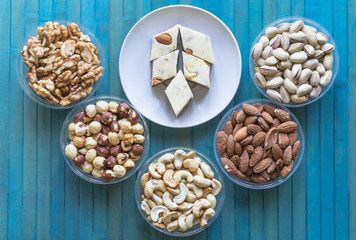   Oriental dessert halva with pistachio, almond, cashew nuts, peanut, walnut  on a  plate. Image. Healthy food. Nuts mix assortment. sweets, Turkish Delight. Isolated  background.. Eastern delicacy