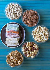   Oriental dessert halva with pistachio, almond, cashew nuts, peanut, walnut  on a  plate. Image. Healthy food. Nuts mix assortment. sweets, Turkish Delight. Isolated  background.. Eastern delicacy