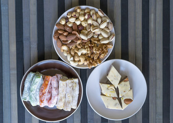 Traditional Turkish Delight. Oriental dessert halva on a  plate. Isolated on background. Eastern delicacy sweets. Healthy food. Nuts mix assortment. image close up nuts, pistachios, almond, cashew nut