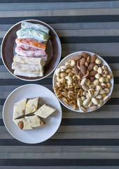 Oriental dessert halva with pistachio, almond, cashew nuts, peanut, walnut  on a  plate. Image. Healthy food. Nuts mix assortment. sweets, Turkish Delight. Isolated  background.. Eastern delicacy