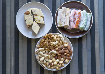 Oriental dessert halva with pistachio, almond, cashew nuts, peanut, walnut  on a  plate. Image. Healthy food. Nuts mix assortment. sweets, Turkish Delight. Isolated  background.. Eastern delicacy