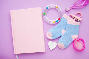 Obraz na płótnie Canvas Newborn baby story. Strow heart and children's toys, scissors, baby bottle, nipple, hairbrush on violet background