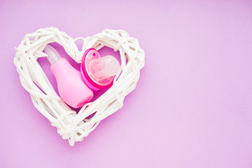 Newborn baby story. Strow heart and children's toys, scissors, baby bottle, nipple, hairbrush on violet background