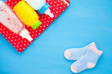 Newborn baby story. Children's toys, scissors, baby bottle, nipple, hairbrush on red background
