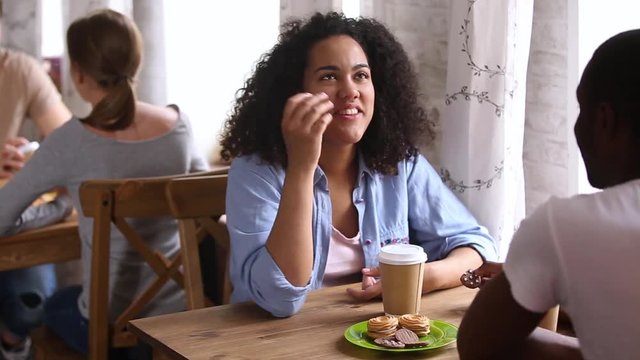 Happy african girl enjoying date with black guy in cafe