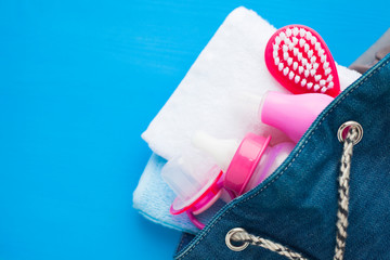 Newborn baby story. Towels and children's toys, scissors, baby bottle, nipple, hairbrush on blue background