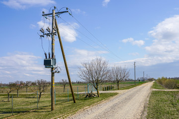 wooden power line pole with electric transformer in rural area