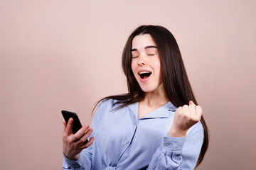Naklejka premium Happy woman winning online. Young excited lady using smart phone. Achievement, celebration, success concept