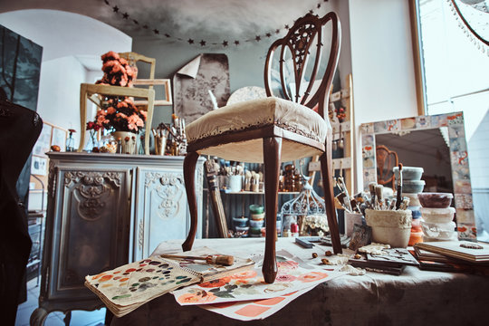 Photo of artist's pretty soiled workshop with chair ready for restouration on the table.