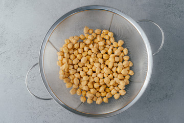 Healthy lifestyle and dieting concept. Top view of garbanzo or chickpeas in sieve. Organic product. Making vegetarian salad. Uncooked food