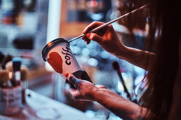 Process of creating a designer coffee cup for a customer. Art studio with necessary tools at...