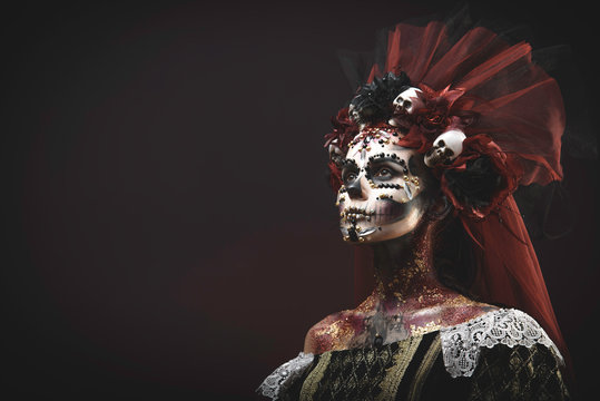 Santa Muerte Young Girl with Artistic Halloween Makeup and with Sculls