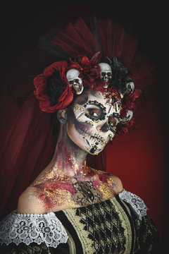 Santa Muerte Young Girl with Artistic Halloween Makeup and with Sculls