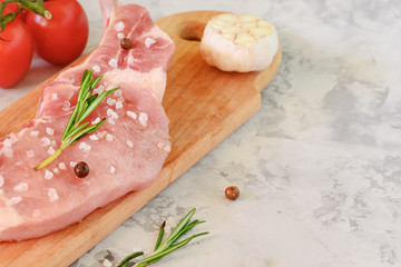 Fresh piece of meat for steak. Raw pork is laid out on a cutting board. Photo with space for text, copy space.