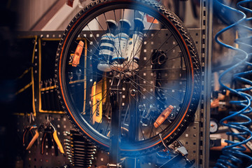 Busy workshop with fixed mountain bicycle on the table.