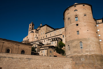 View from below of the imposing ducal palace of Urbino, Italy, during a splendid sunny summer day.