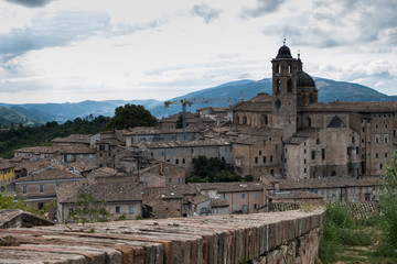 Panoramic view of the ducal palace of Urbino in central Italy with a dramatic sky.