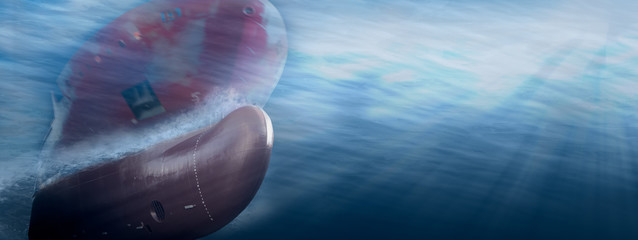 Big cargo ship sailing in the sea to International Shipping container terminal. Close up image detail ships bow, underwater view.